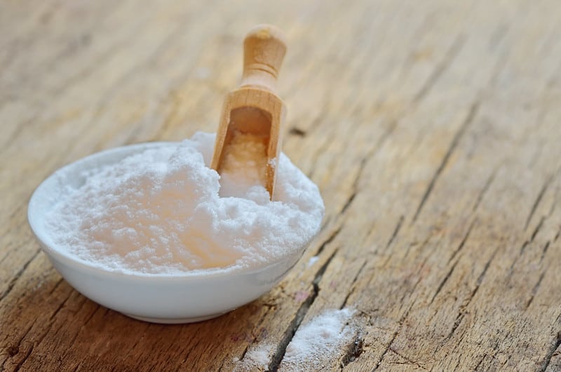 baking soda in bowl with wooden scoop